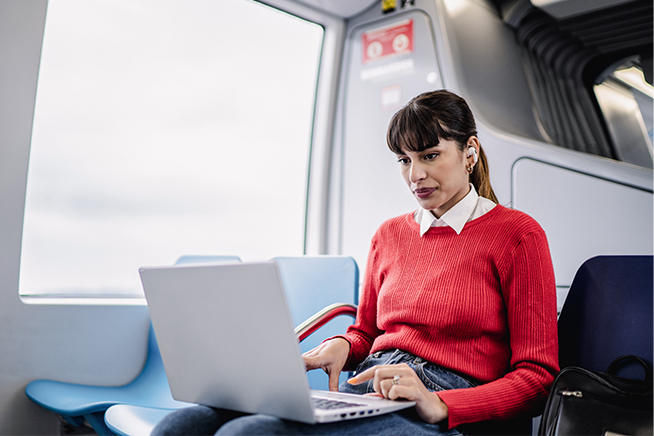 Woman using laptop on a bus.
